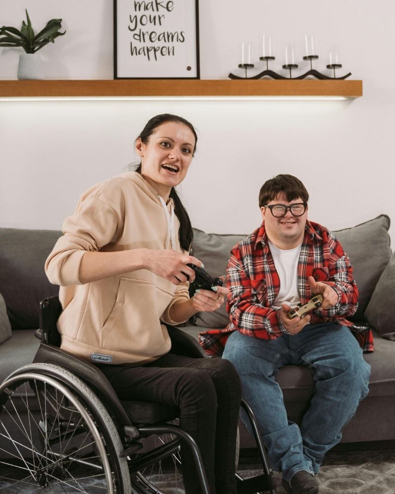 woman in wheelchair and boy on lounge gaming